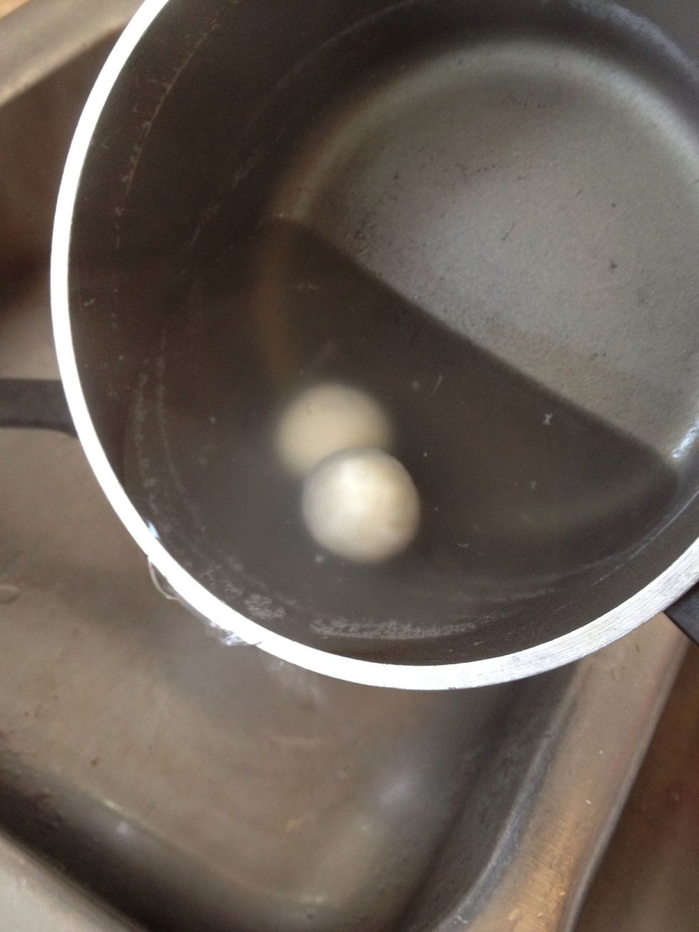 After the rice balls are done, pour out some water to the point it's half covering the rice balls.