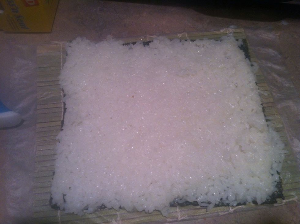 After the rice is cold and super sticky.... ( keep your hands wet it will keep the rice from sticking to your hands) spread over the seaweed. 1/4 inch thick.