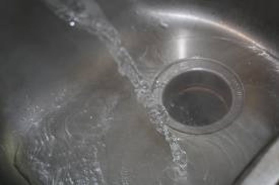 After the rice soaks up the water, pour the water down the sink.