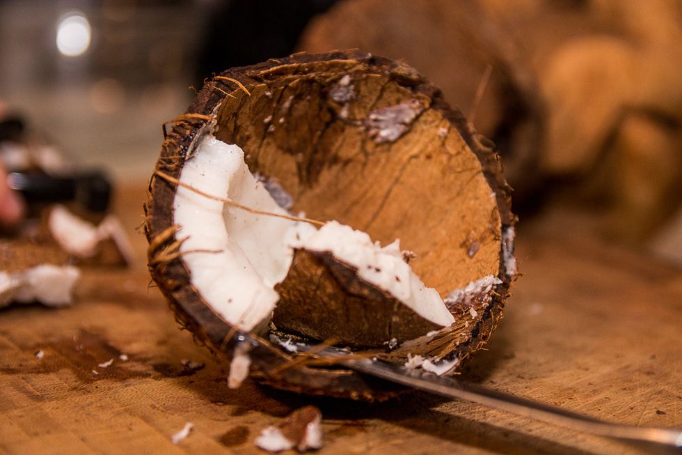 After the slits are made, squeeze the flat side of your butter knife between the white coconut meat and the soon to be bikini top. The meat should pop out in chunks.