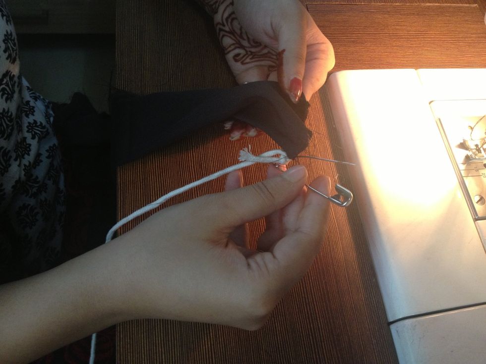 After the stitched tube is ready, lock one end of the stitched tube of the fabric with a safety pin connected with a strong thread.