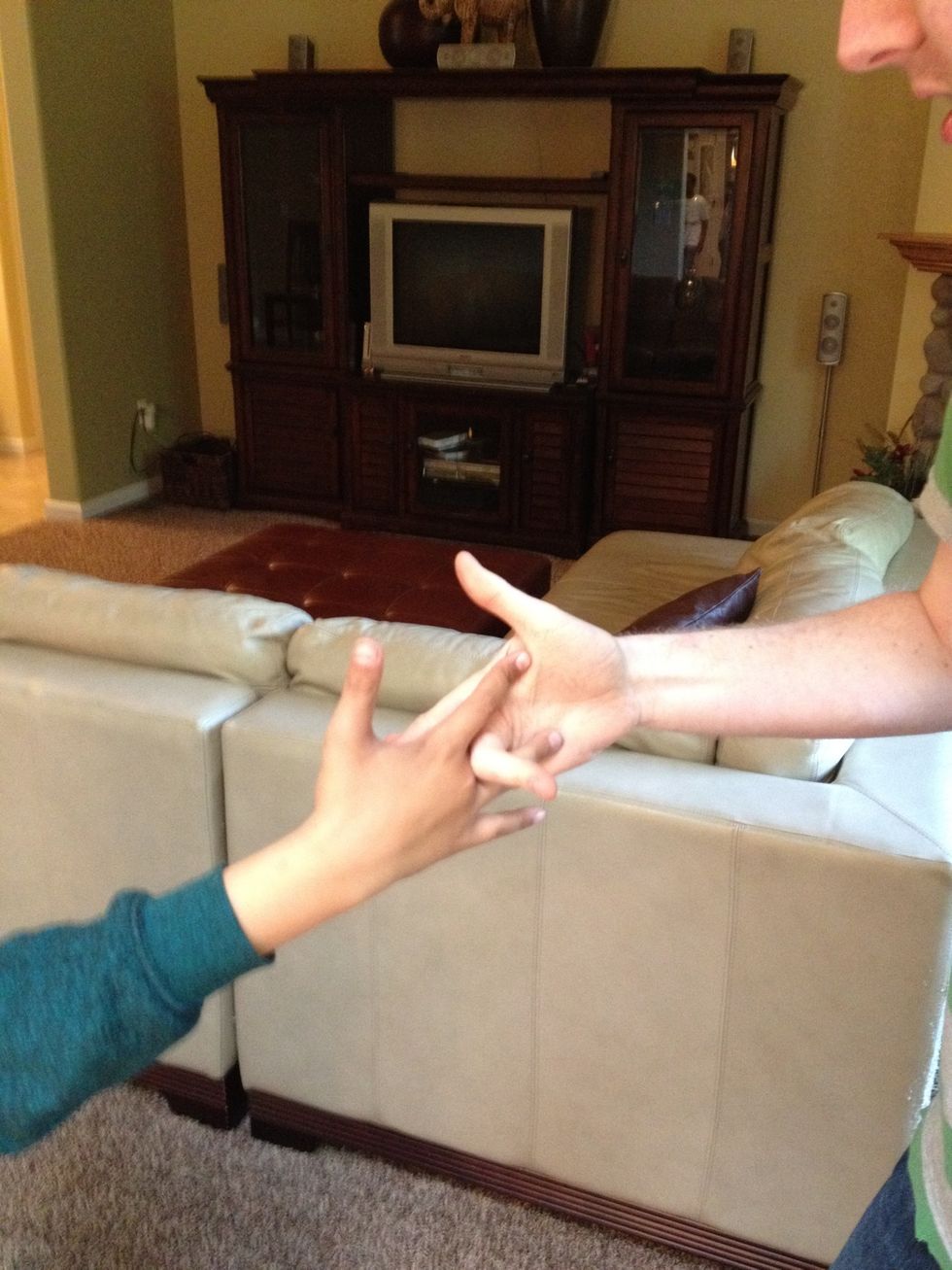 After the Thumb Hug return to a standard high five and link middle fingers with your middle finger closer to your body. Rotate wrist clockwise 90 degrees. And wiggle middle fingers.