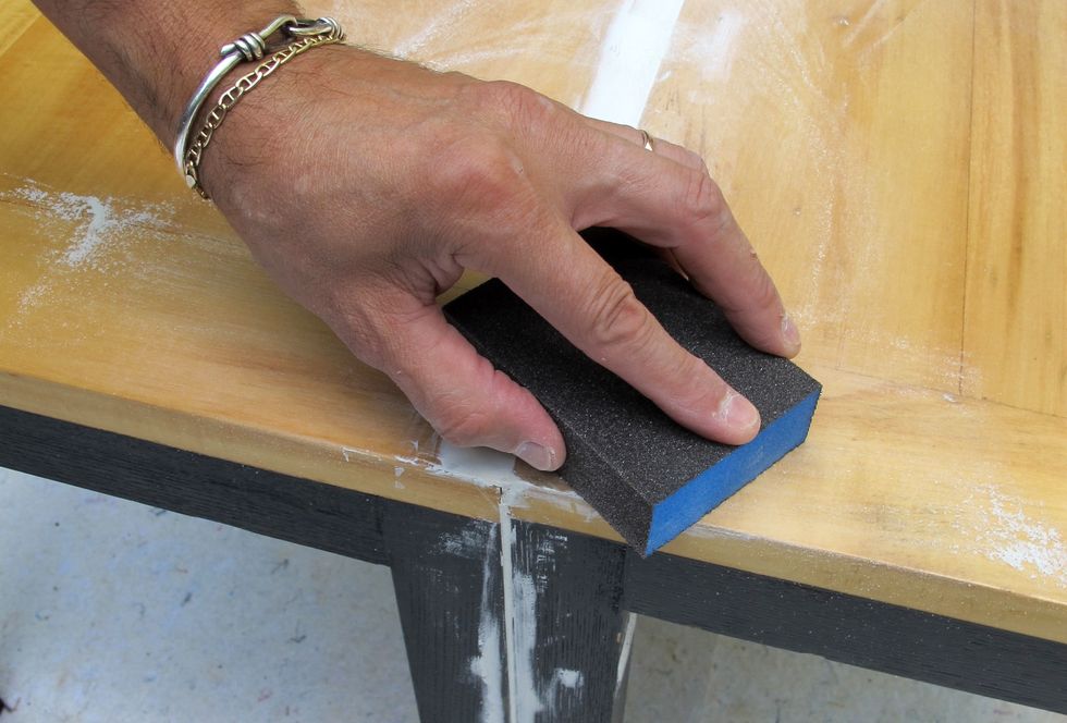 After the wood patch has dried, sand the surface of the chairs prior to painting.