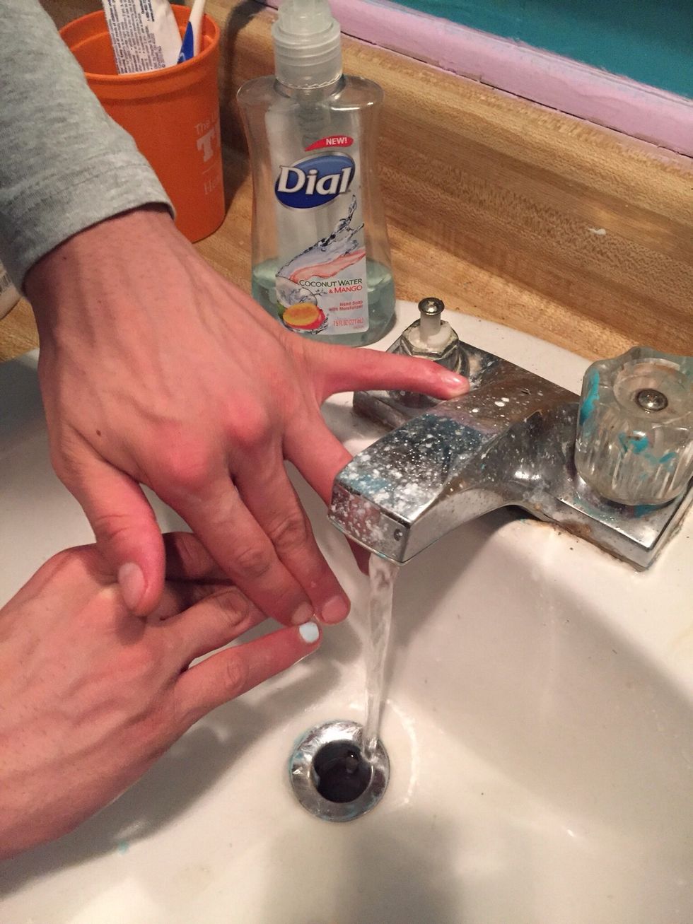 After they are fully dry, wash your hands with soap and water and rub around your nails for about two minutes. The excess paint on your skin should come off.