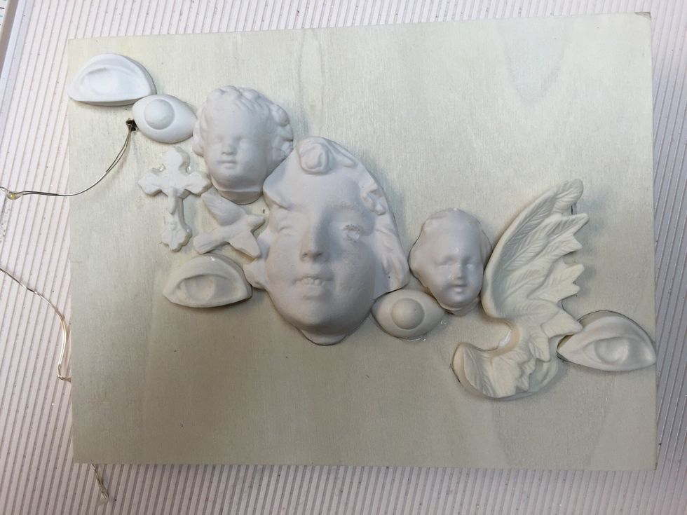 After threading the wire with the lights assemble your Relics crosswise. You'll find they tend to fit together like pieces of a puzzle! I used a pencil to outline their positions and glue down