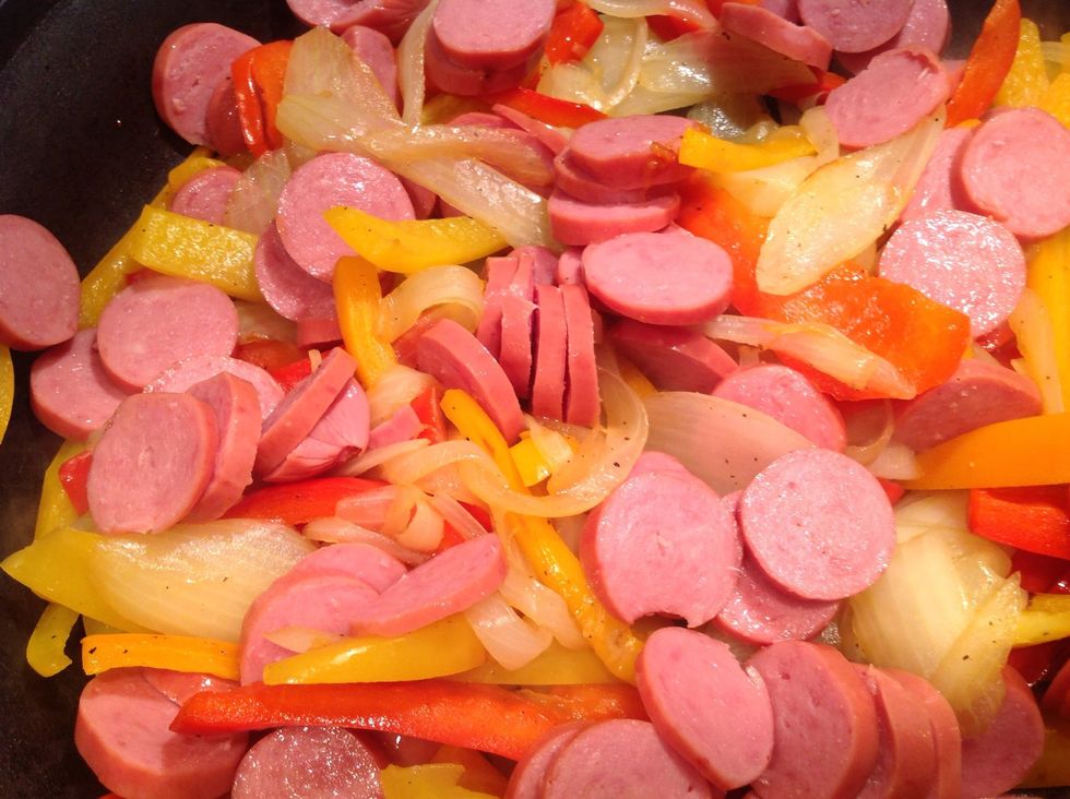 After vegetables begin to soften, add cut up sausage.  Stir sausage and peppers together.