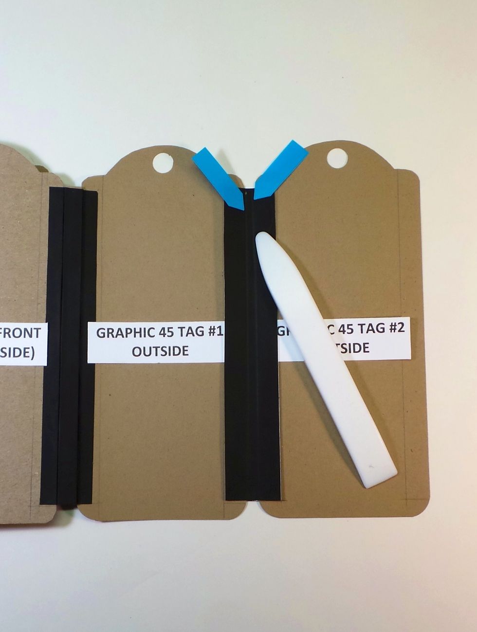 After you adhere the new Tyvek strip in the center, burnish along the edges of the tags - this will help you fold the tags to complete the finishing. This 1/4" "spine" is just Tyvek.