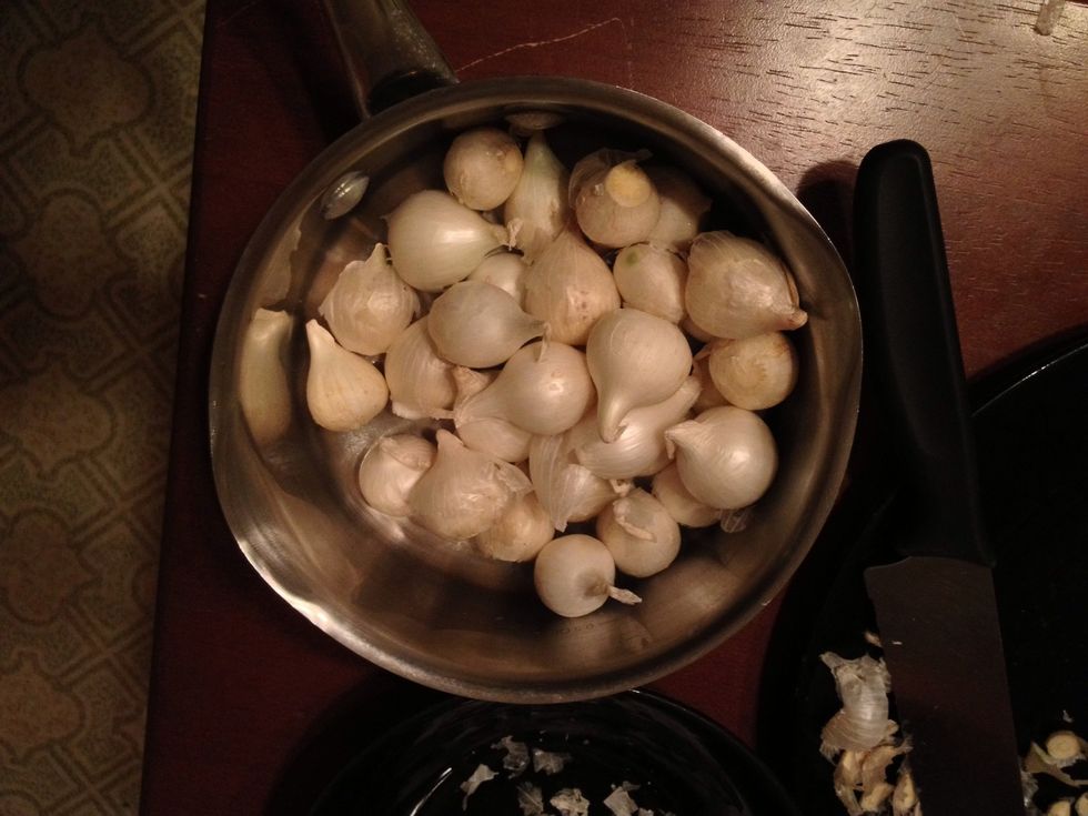 After you are finished cutting the root end, place the onions in the pot.