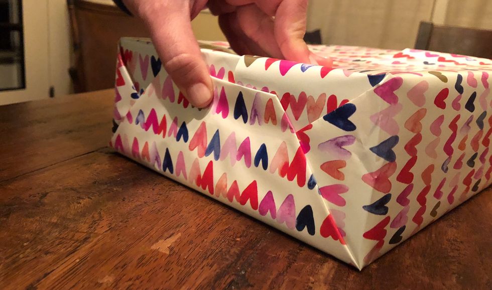 After you ensure that all of the folds are neatly creased, secure the end with tape.