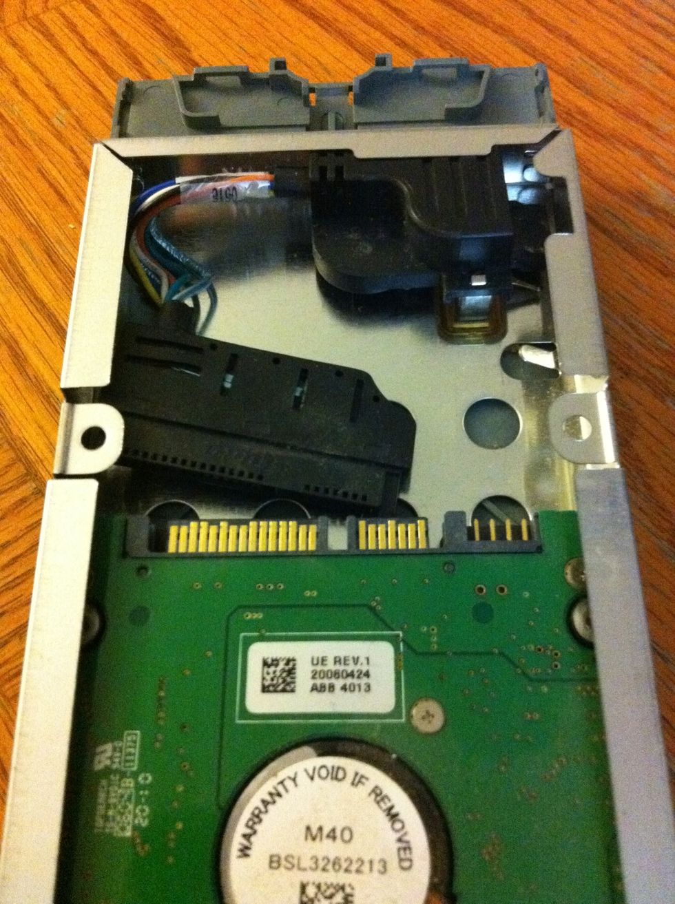 After you get the HD over the grey plastic lip, disconnect the cable attached to the top of the hard drive (it might have slipped off already)