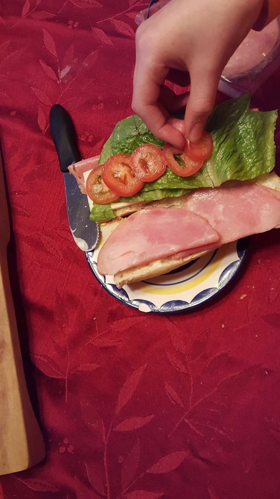 after you have cut all of the slices of tomato needed lay them on the bread. if you want to have a small mess then put the tomato slices on the side that has the lettuce.