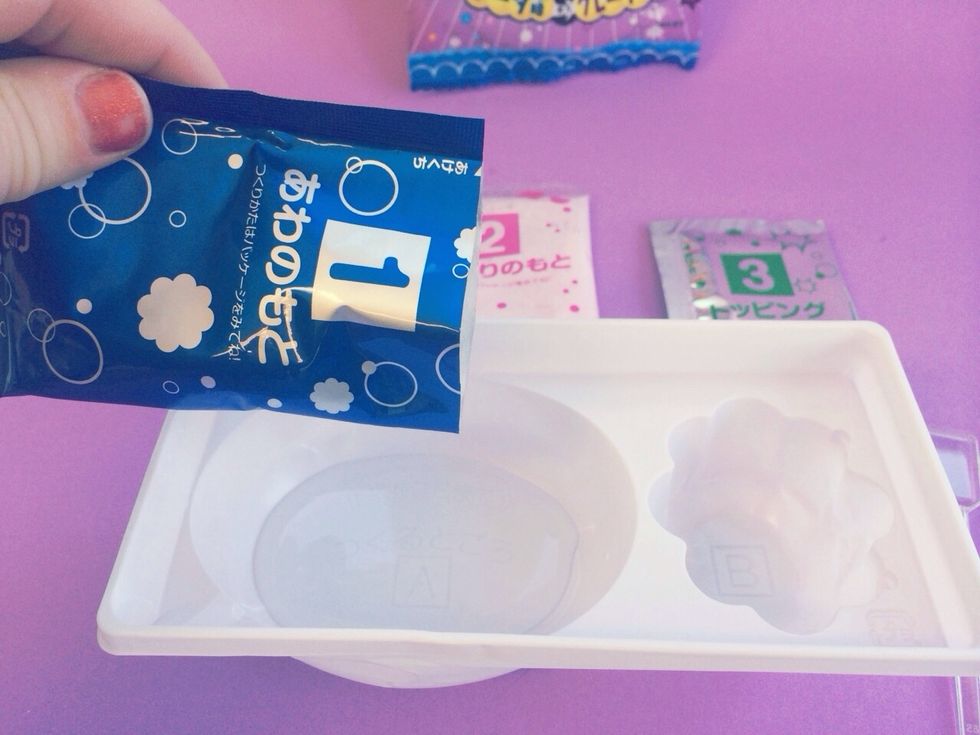 After you have filled Oval side of container to bottom line with Water-----------------------------------------------------Dump BLUE Packet #1 Into water slowly while mixing at same time --