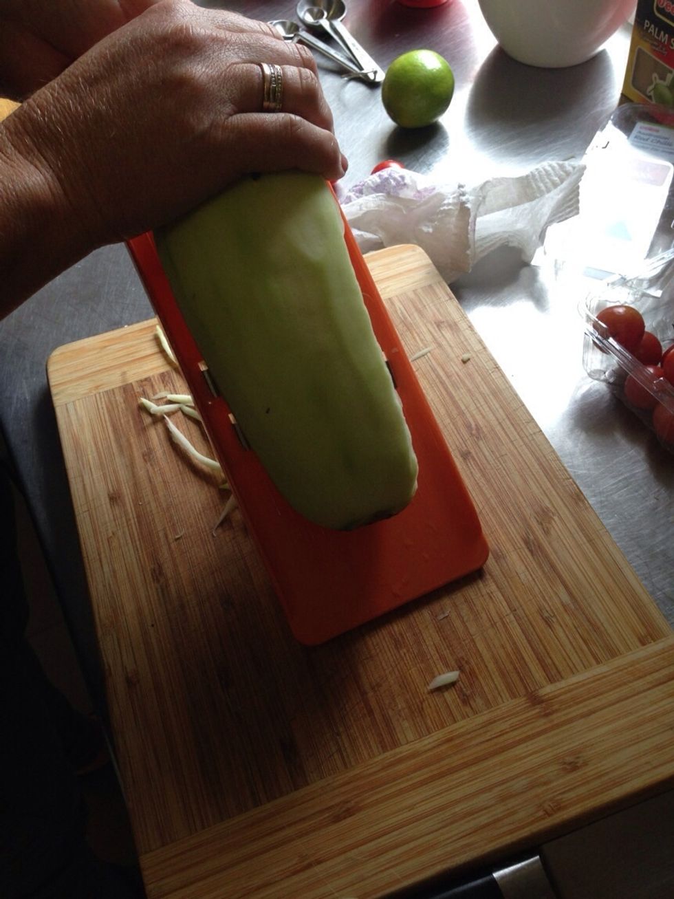 After you have peeled the green papaya, lay the papaya on it's side and push the top down. The first grate is always the hardest but after that it is quite easy.
