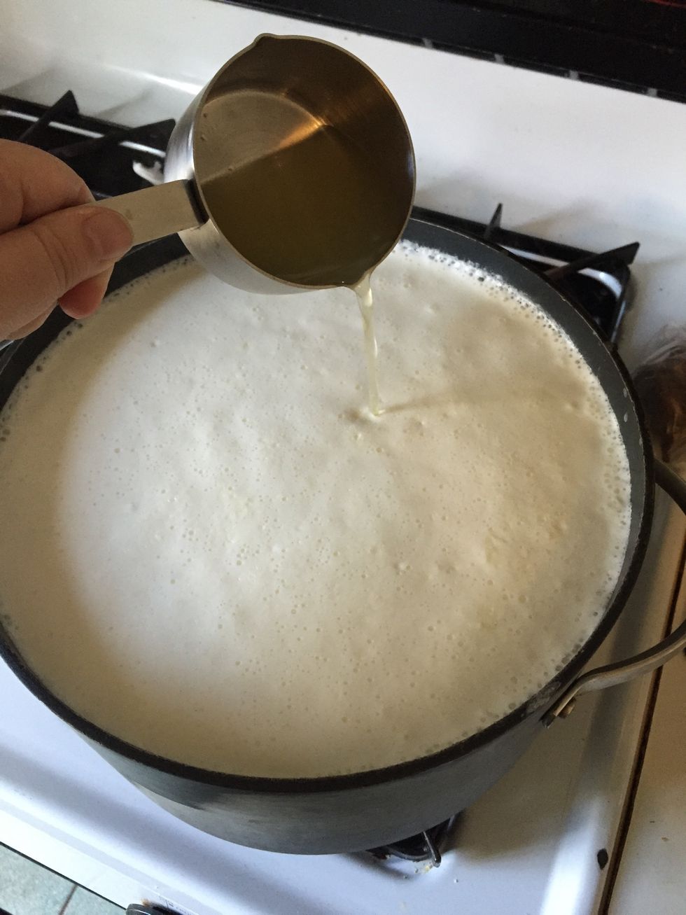 After you have removed the pot from the burner, slowly add 1/2 cup of lemon juice to the milk.
