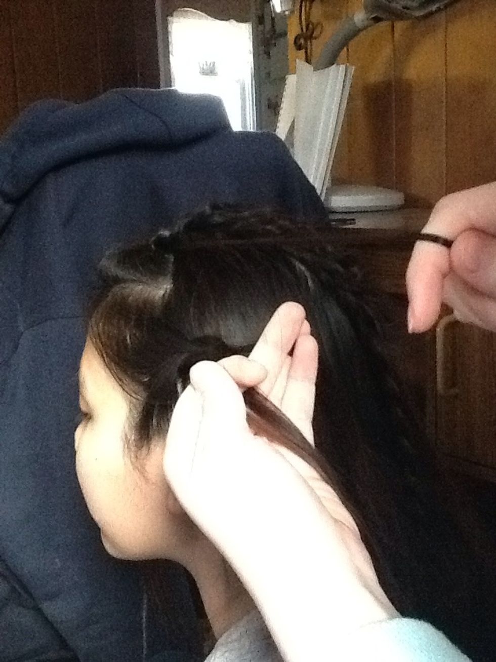 After you repeat that and put the bottom over the middle. When you cross the top piece over the middle add the first piece of hair from the other braid into the top piece before crossing it over.