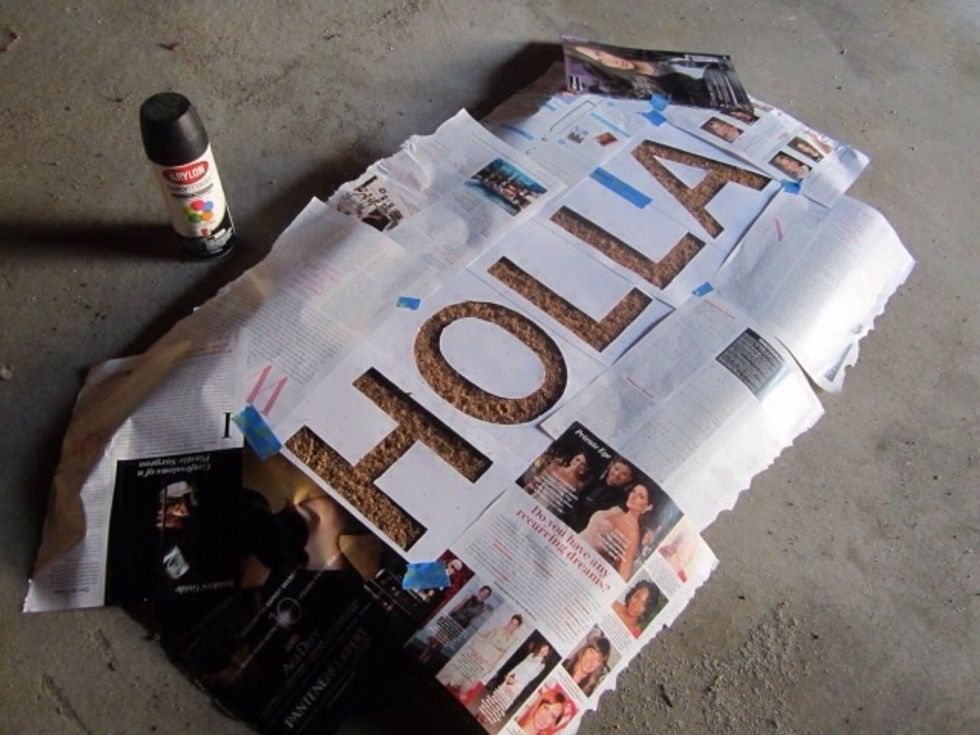 After you've arranged the letters use a spray adhesive to keep the letters in place. Surround the rest of the letters with newspaper. Then spray with your color choice in even strokes.