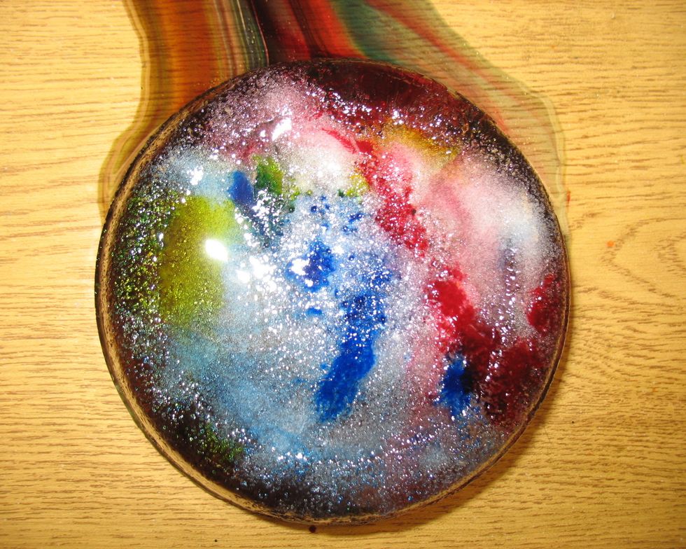 After your art has melted a bit, put it in your tub, sink, or on a linoleum or tile floor. Take it out of the container. Observe what happens when the colored water spreads out.