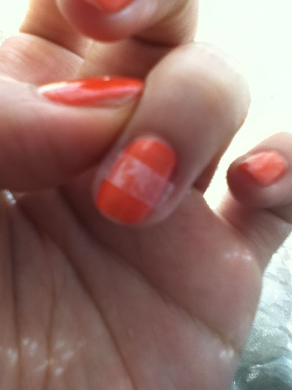 After your nails are completely dry. cut a small piece of tape and place it in the middle of your nail