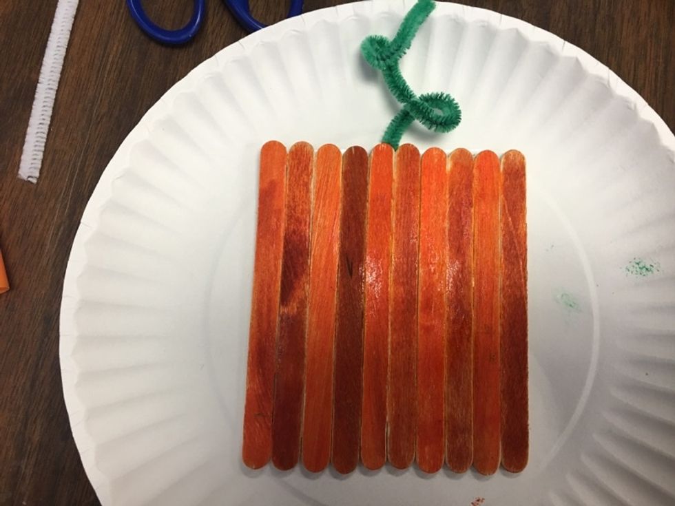 After your sticks are glued or taped, take your pipe cleaner and glue or tape it to the back to create a vine.