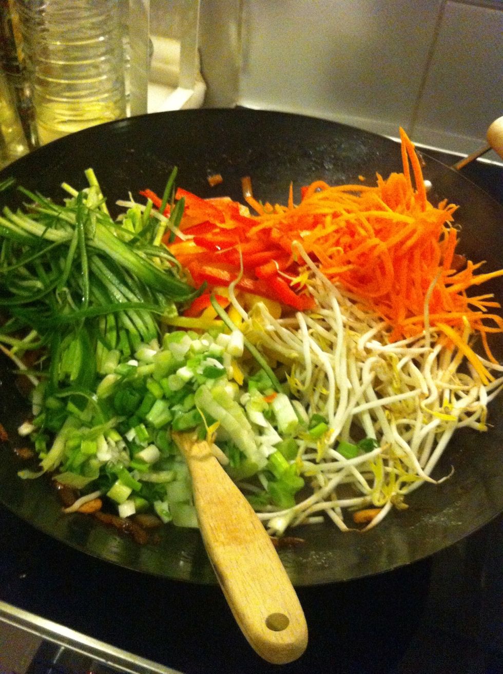 After1/2 minutes frying, add rest of the vegetables and soybean sprouts all at once and let them fry on very hit stove for 2-3 minutes. Vegetables should be semi-cooked.