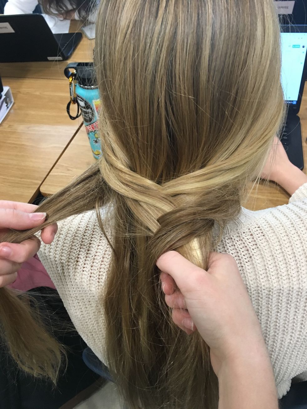 Afterwards separating your hair, start the fishtail braid by taking a small piece of hair from the far end of the left side and bring it over to the inside of the right half.