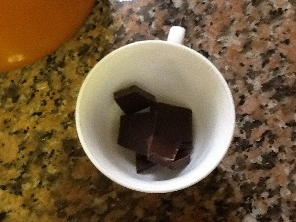 Agafem una tassa i hi posem una mica de xocolata. Pot ser negra o amb llet