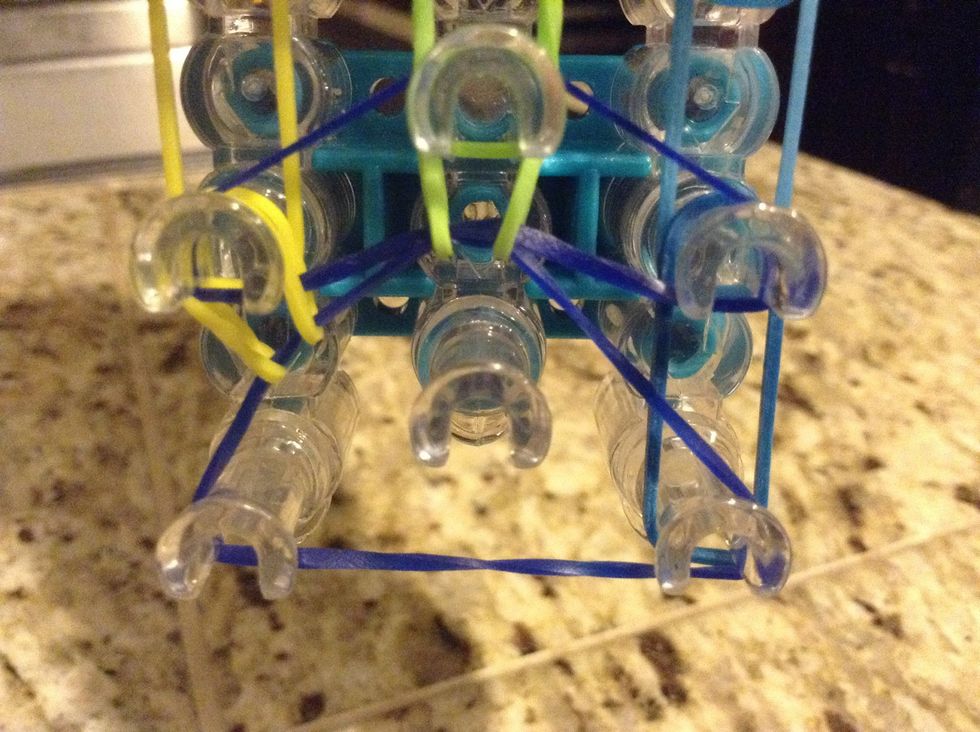 Again hook the bottom rubber band of the middle to the loom hook in front of it