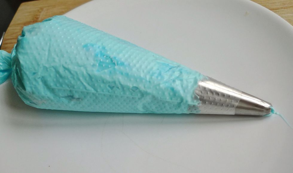 Again put the blue colored frosting into a piping bag.