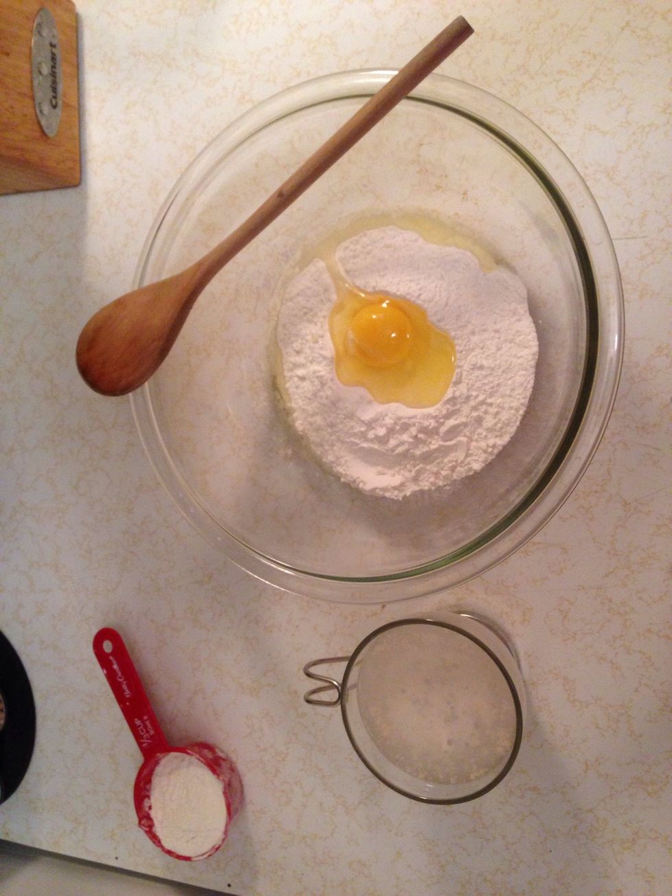 Again, take a cup with warm water, pinch of sugar and crumble some yeast in it. When it's floating, dump it in your bowl with flour and egg. Use a wooden spoon to work out dough.