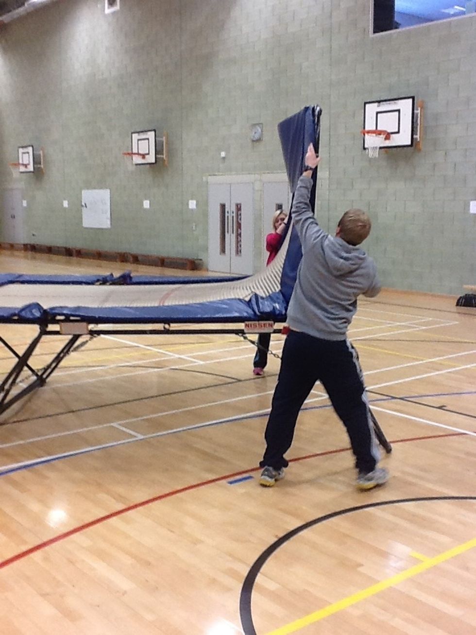 Again, with sufficient people to help, unfold the other side of the trampoline. The tension will build in the bed so ensure you have a good grip of the frame.