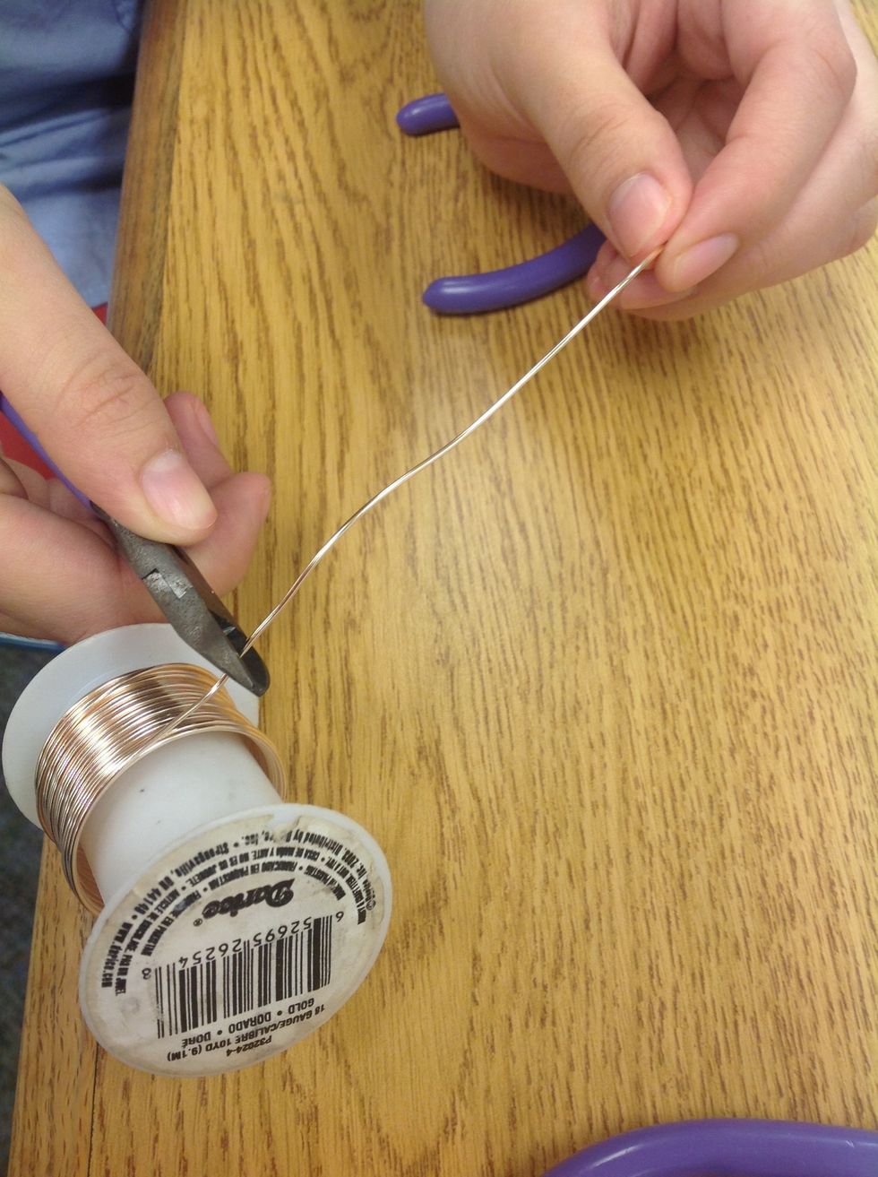 Agare hilo met\u00e1lico como tres pulgadas y c\u00f3rtelo.