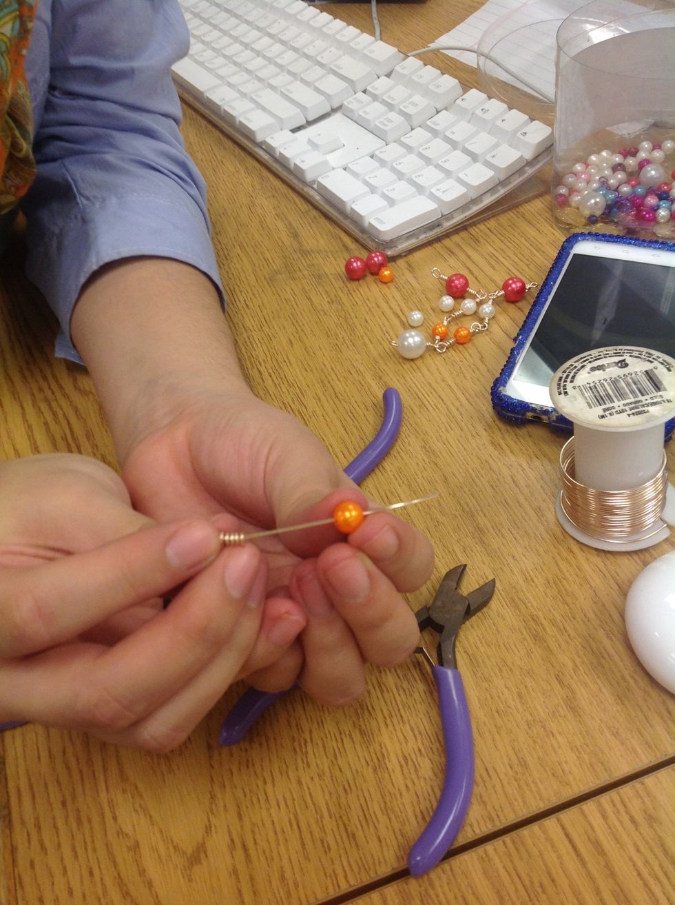 Agare una cuenta y p\u00f3ngala en el hilo.