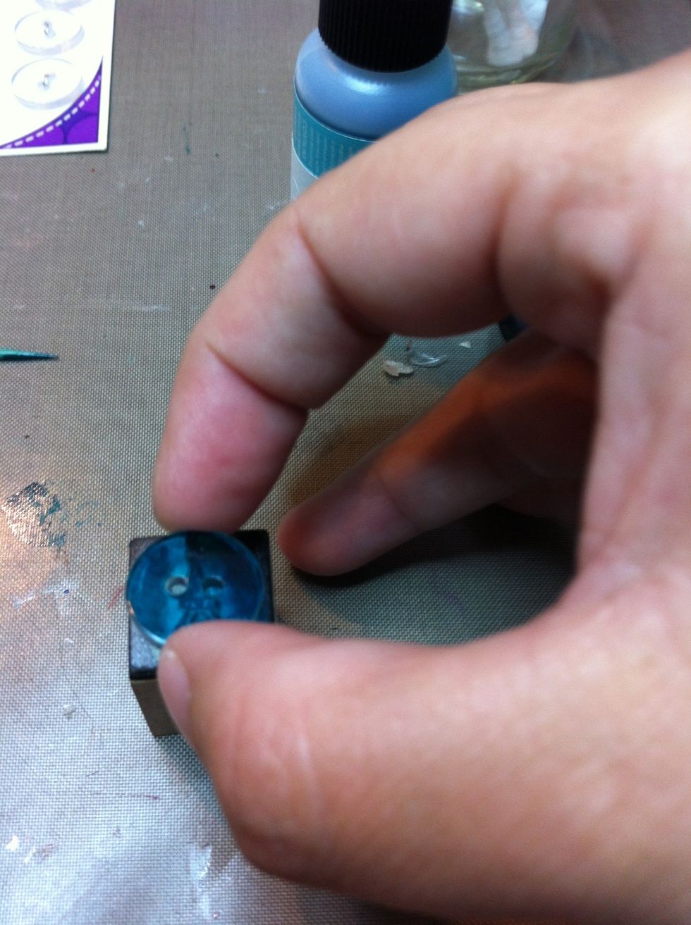 Align the button over the stamp with the inked side facing up (you will be stamping the blank side). Make sure it's where you want it before you place it on the inked stamp!