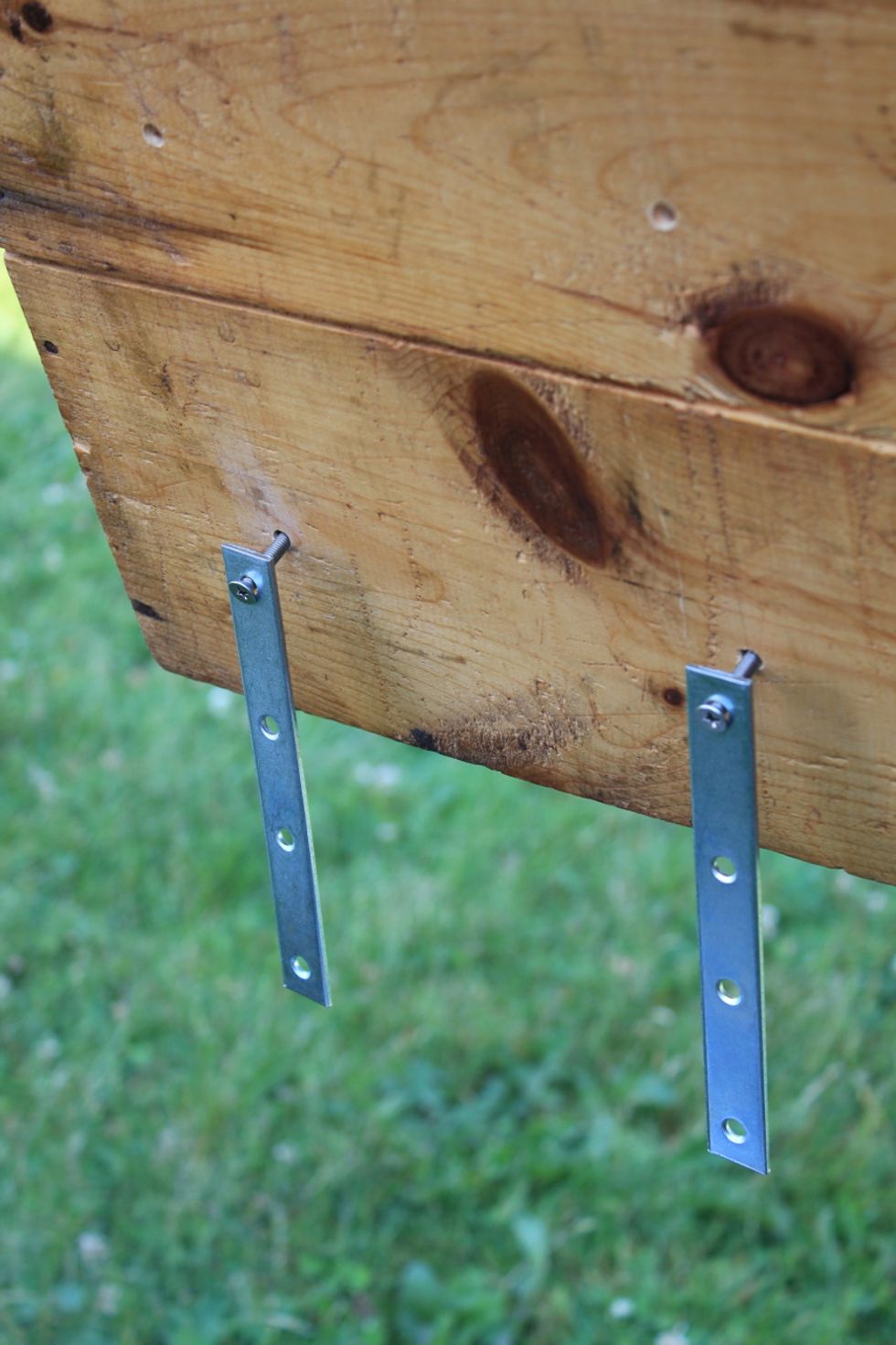 Allow the fastening bars to hang down.  Next, place the Trunk on the rear rack and swivel the bars to pass beneath the rack to the other side where the bolts will re-enter the trunk.