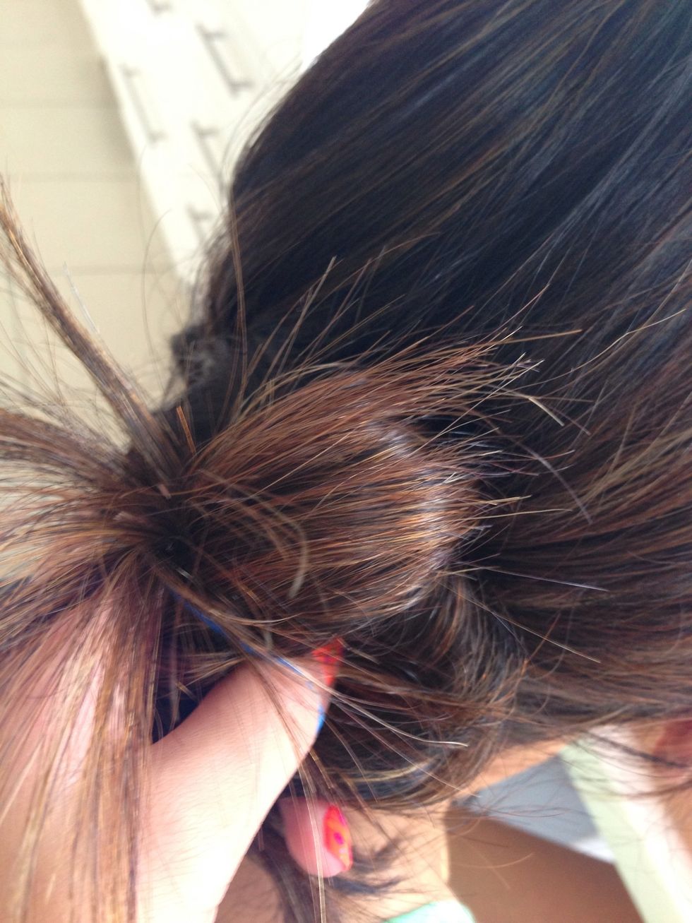 Almost scrunch your hair into a messy bun and then tie a thin hair elastic around it.