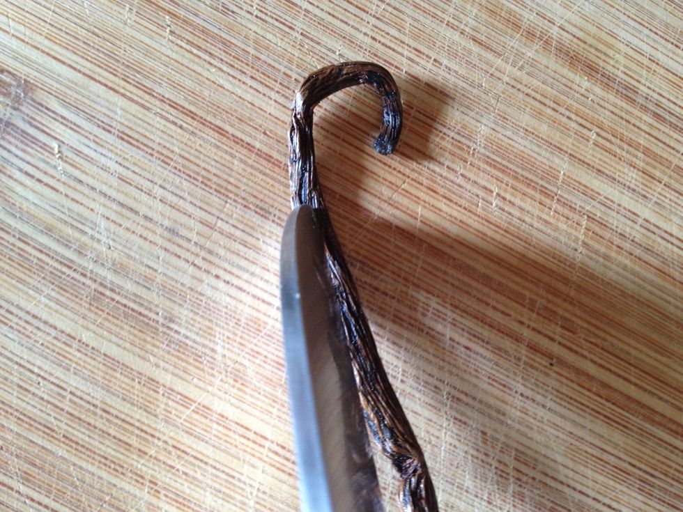 Along the wide, flat part of the bean, cut from top to bottom and split it open.