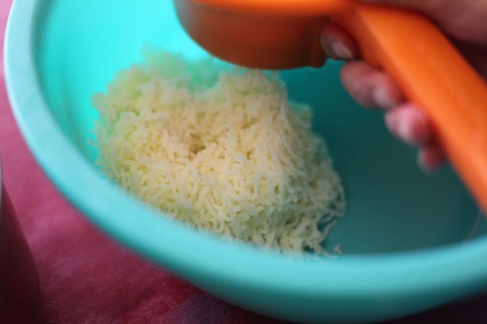 Alright, move quickly. Drain the water from the potatoes. Mash it up as fine as you can. We're just using an oversize hand grinder. Please use a spoon to handle your potatoes.
