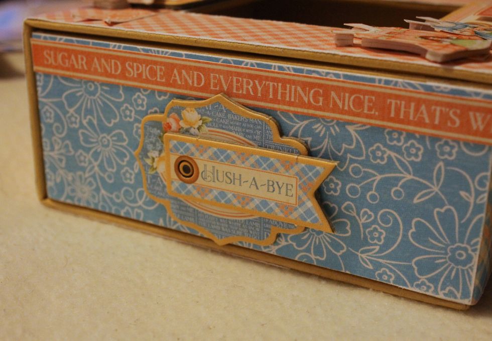 Also adhere two small sentiment strips and chipboard pieces to the left and right side of the box.