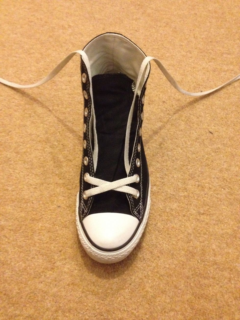 Always awkward - the first kiss. Take both laces and cross them over each other before threading over the sneaker and back in through the second eyelets.