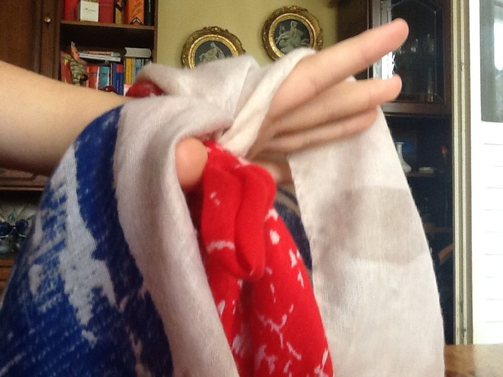 And flip it around the knot. You should now have two holes around the knot like this. Check out the How To Make Your Scarf Look Like A Vest guide if there's any confusion.