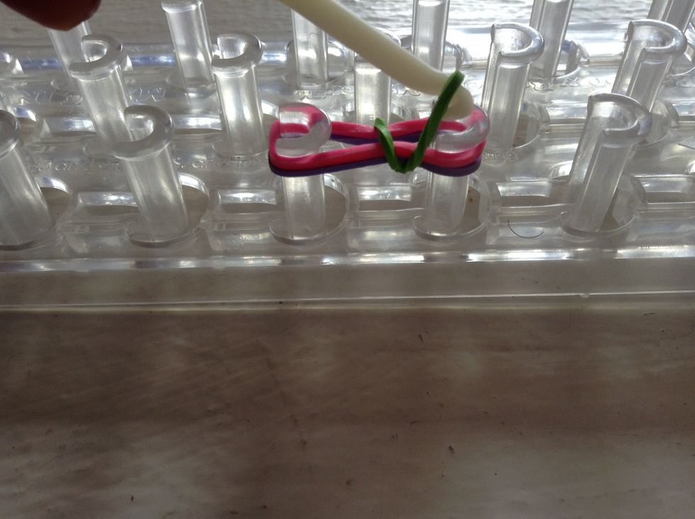 And now you take your pin and pull bottom right side of the rubber-band up and over.