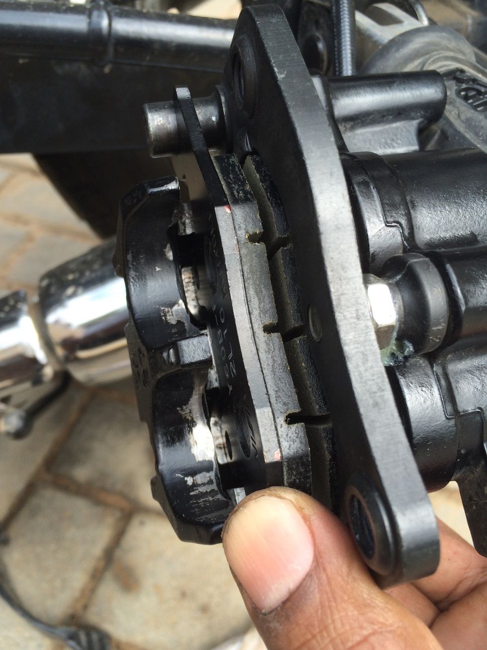 And rotate it inwards, note the two arrow like hooks of the flat spring should keep this pad towards the outside of caliper