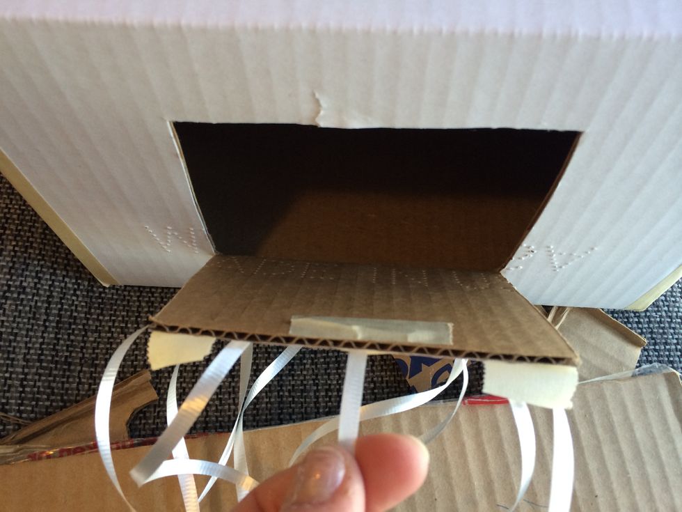 ...and THE one that opens it is securely attached. I cut a slit in the door, pull the ribbon through, tie it to a paper clip and tape that to the inside.