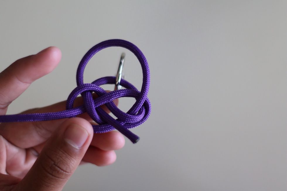 And through the middle hole of the weave. Like so in the picture above.