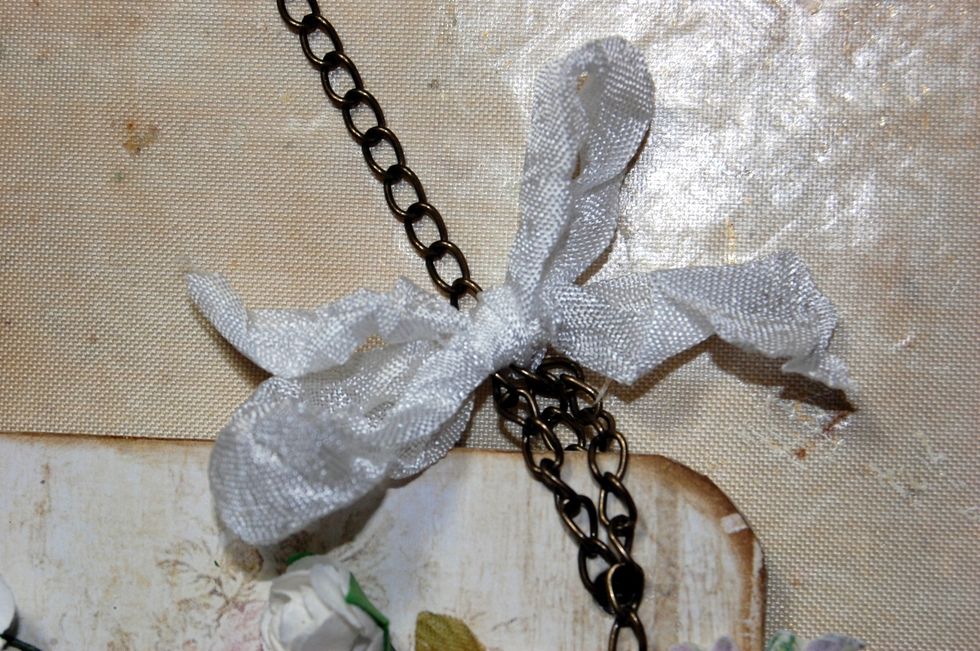 And tie the ribbon into a bow. Repeat on the other side of the plaque leaving enough chain to hang it at a nice height.