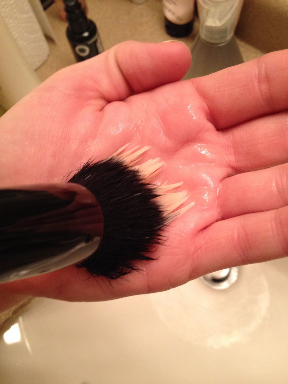 Angle the brush downward into the soap in your hand (or plate), making sure to saturate the head of the makeup brush with your cleaning product.