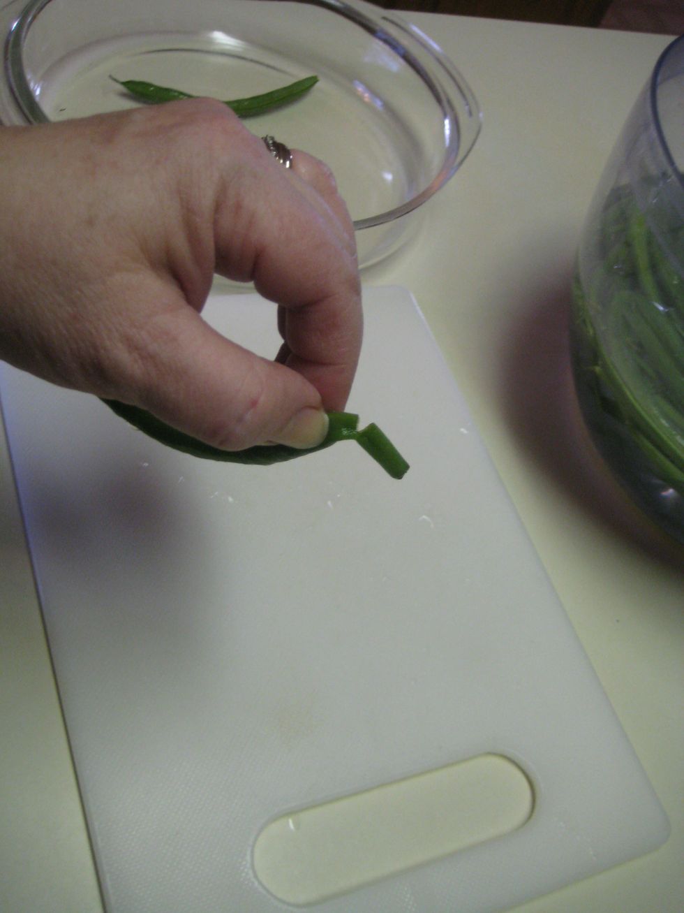 Another option is to tear the end to be snapped and pulled down to remove the thick seam of the bean. Leave the other curly end of the bean for presentation.