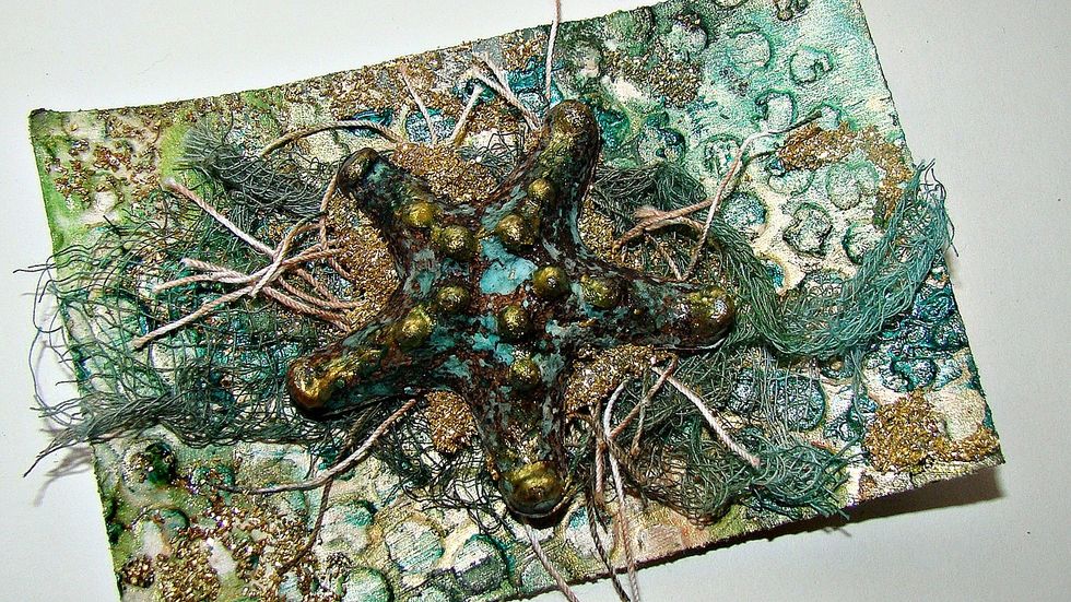 Another starfish was altered and Colorations Spray Siesta Key and Warm were used, as well as Metal Effects in Gold. Glass glitter and hemp twine stained with Warm were used to achieve this look.