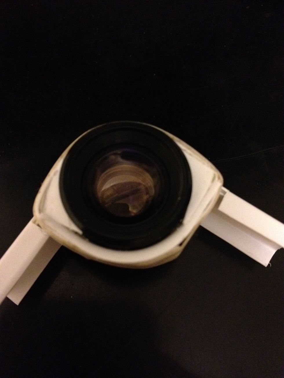Another unnecessary step: cut two small pieces of plastic to cover the white-tack that fills the space between the lens and the holder.