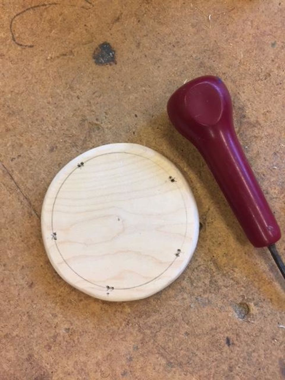 Anv\u00e4nd en passare och g\u00f6r en cirkel 0,5 cm innanf\u00f6r kanten p\u00e5 den minsta cirkeln. Ta en penna och s\u00e4tt fem kryss j\u00e4mnt f\u00f6rdelade p\u00e5 linjen. Anv\u00e4nd en syl f\u00f6r att g\u00f6ra tv\u00e5 h\u00e5l vid varje kryss.